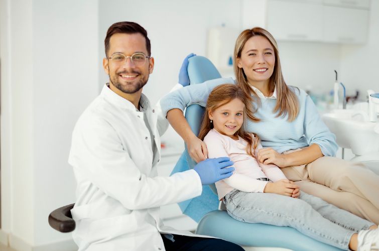 Dentist conducting a friendly checkup on her daughter with her mother,