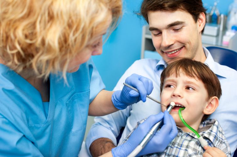 Dentist conducting thorough teeth checkup to the boy